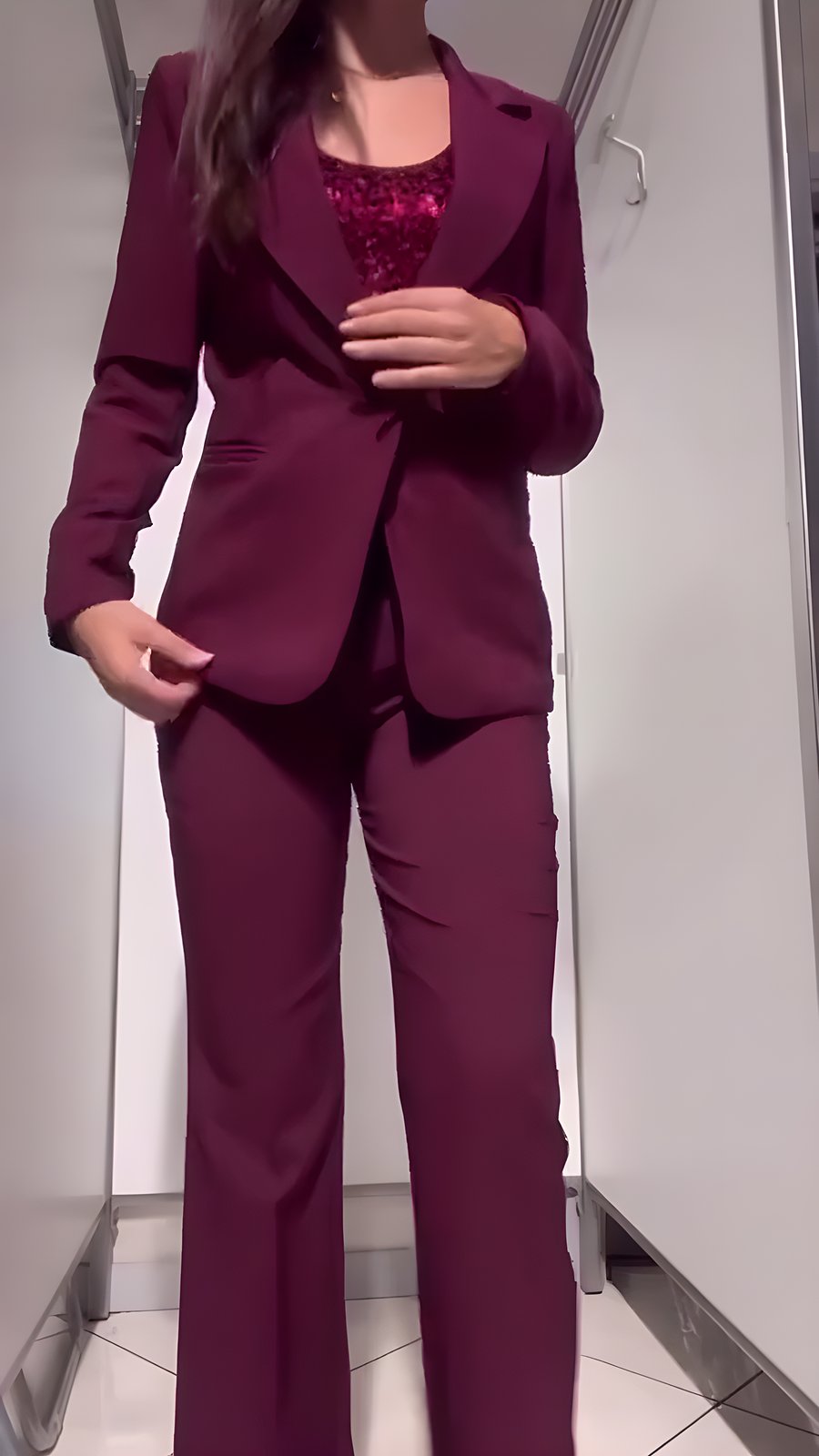 Completo giacca e pantalone borgogna con top in paillettes, nel camerino di XStore